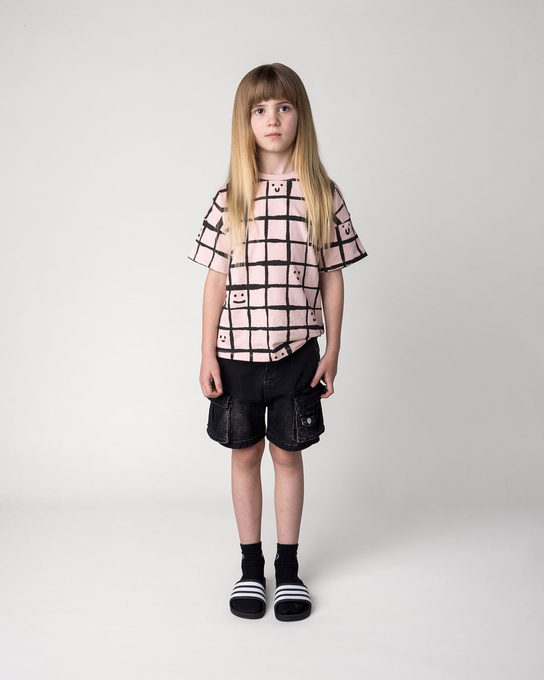 Kid wearing the Happy Squares Tee in dusty pink, front view