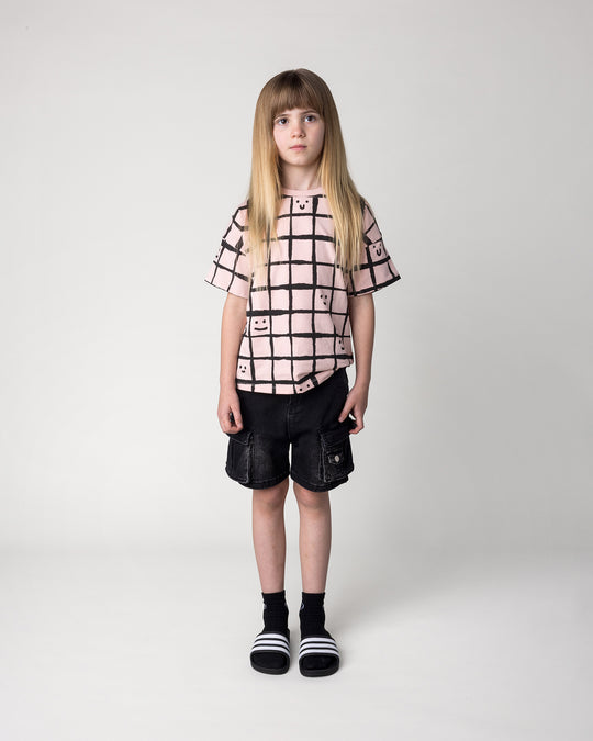 Kid wearing the Happy Squares Tee in dusty pink, front view