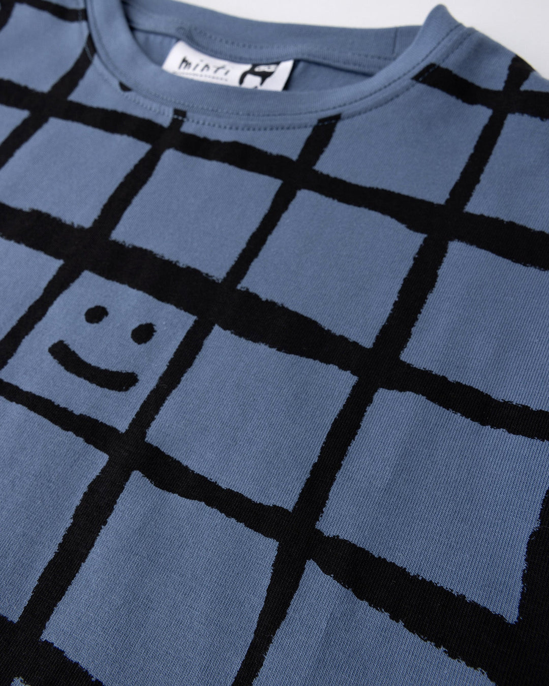 Close up detail of the Happy Squares Tee in muted blue