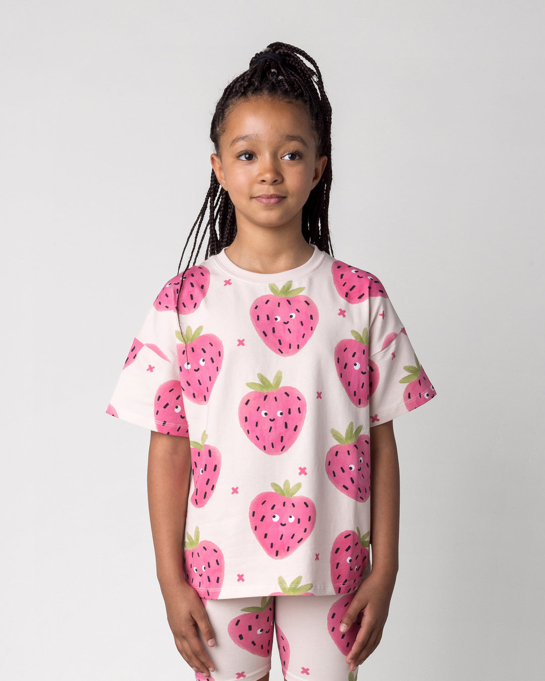 Close up of the Happy Strawberry Tee in cream on a kid, front view
