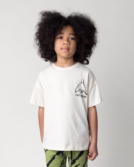 Close up of the Just Hanging Tee in cream on a kid, front view