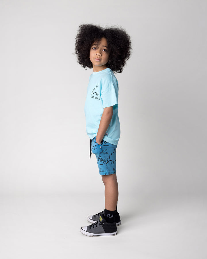 Kid wearing the Just Hanging Tee in light aqua with the Just Hanging Short in sky wash, side view
