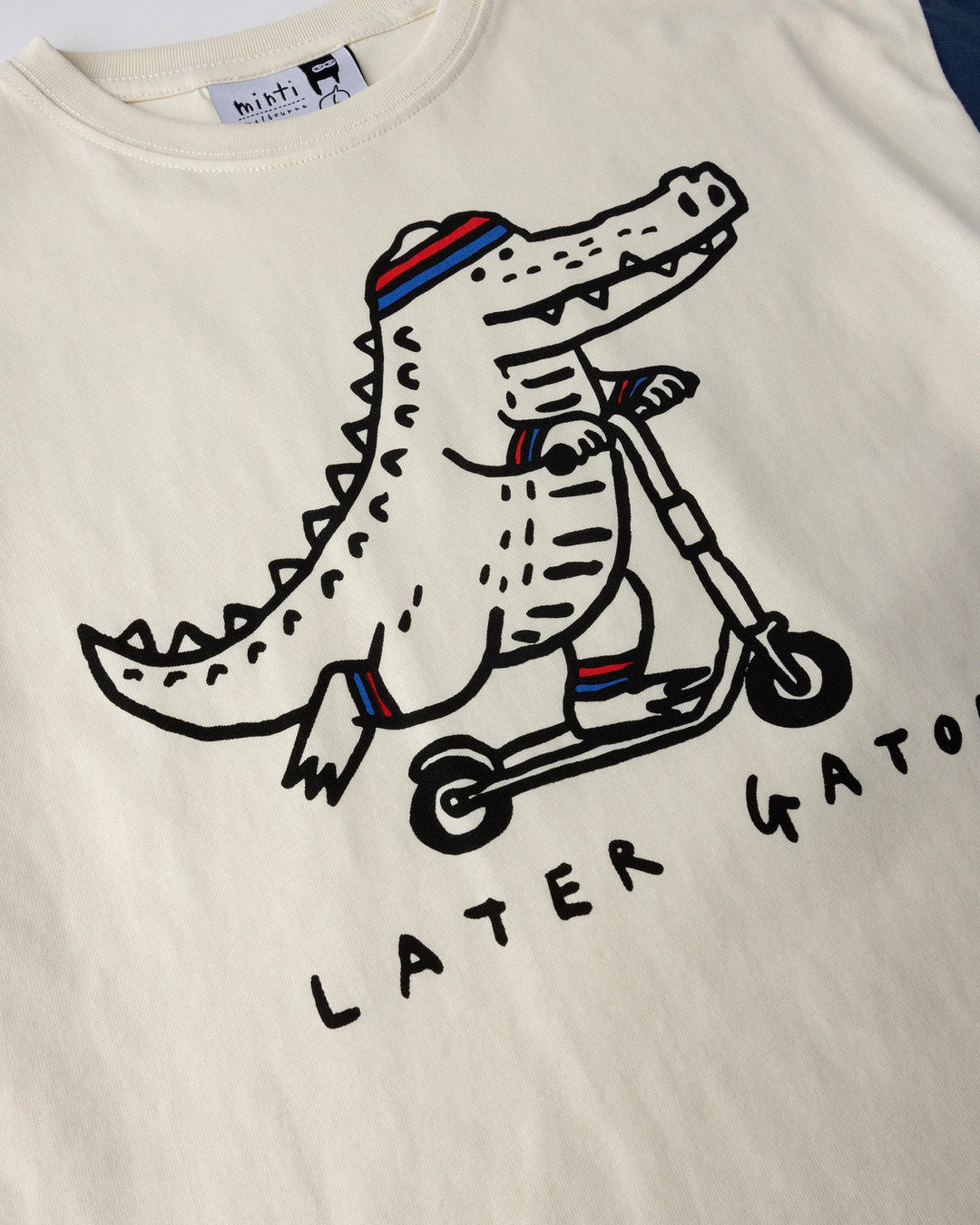 Close up of the Later Gator Tee print in cream and blues