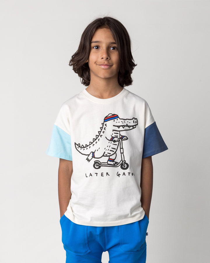 Close up of the Later Gator Tee in cream and blues on a kid, front view