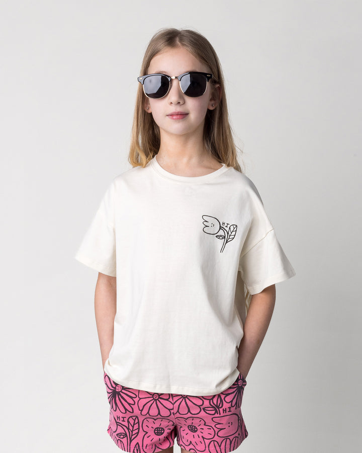 Close up of the Pocket Flower Tee in cream on a kid, front view