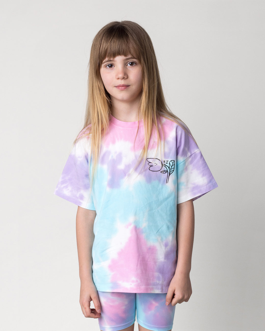 Close up of the Pocket Flower Tee in tie dye on a kid, front view