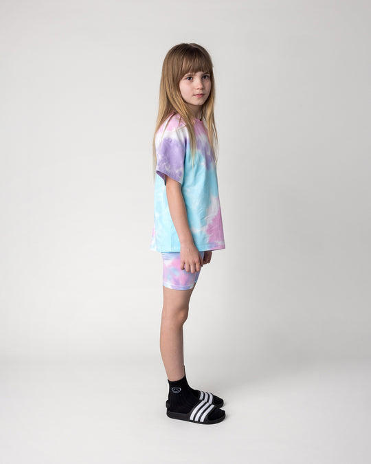 Kid wearing the Pocket Flower Tee in tie dye with the Tie Dye Bike Pant in multi, side view