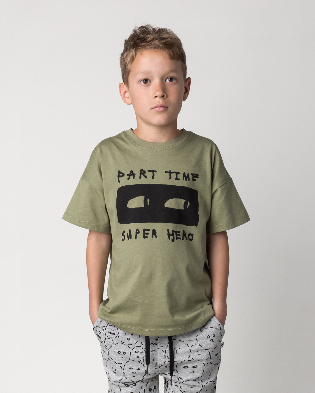 Close up of the Part Time Super Hero Tee in light khaki on a kid, front view