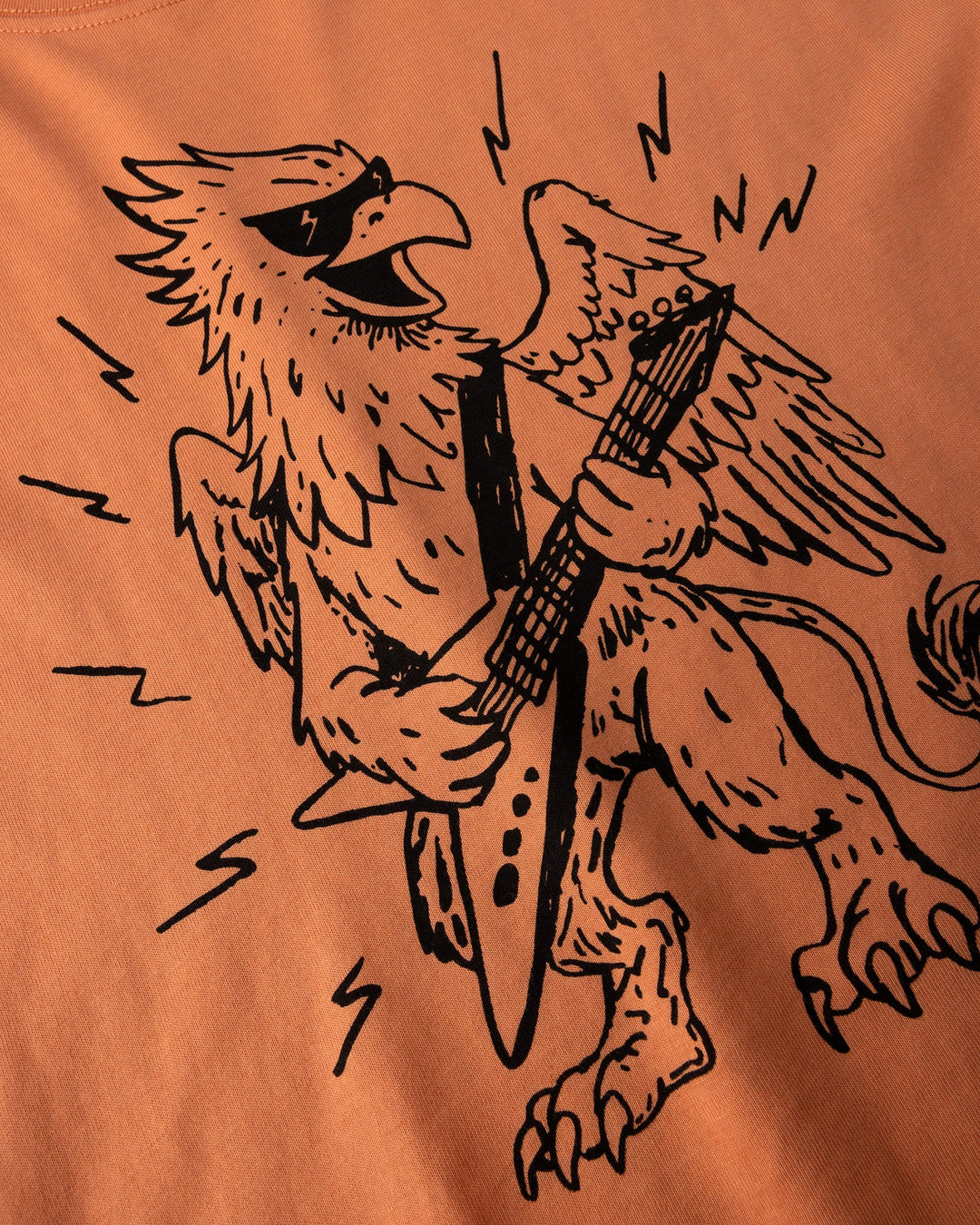 Close up of the Rock Griffin Tee print in light orange