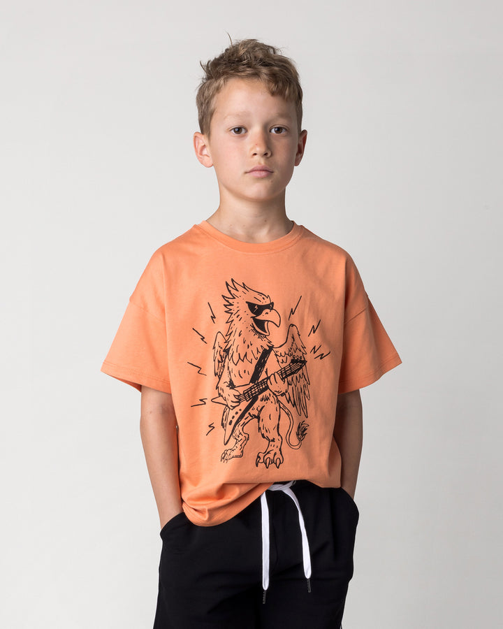 Close up of the Rock Griffin Tee in light orange on a kid, front view