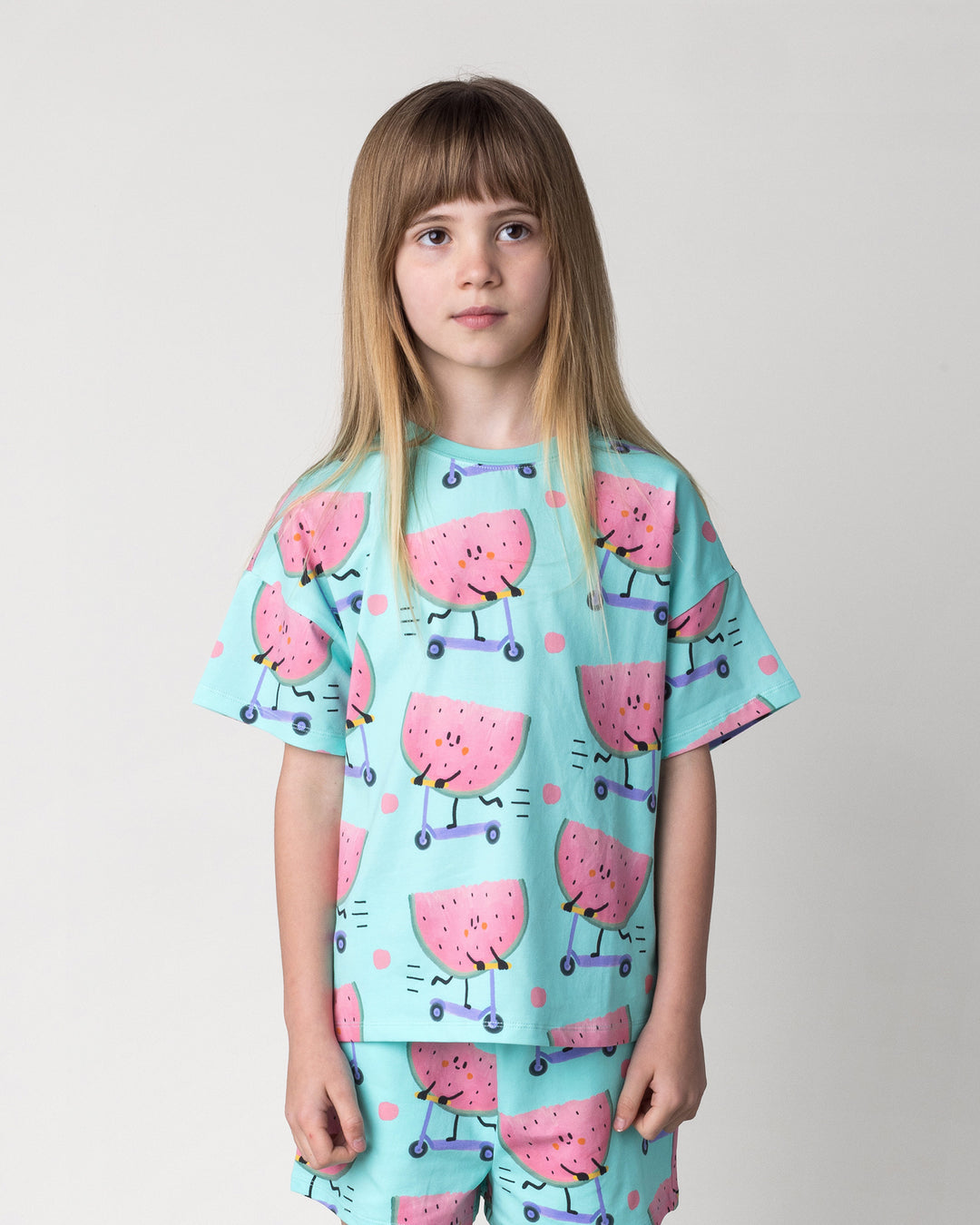 Close up of the Scooting Watermelon Tee in light mint on a kid, front view