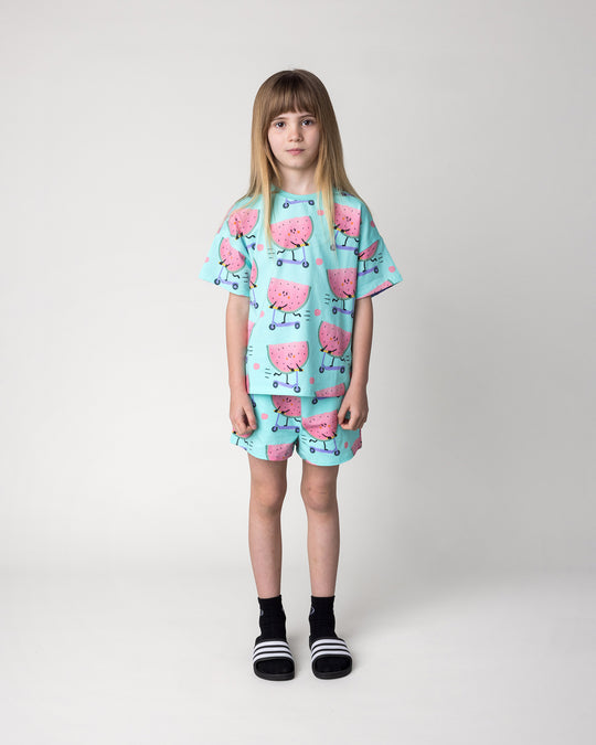 Kid wearing the Scooting Watermelon Tee in light mint with the Scooting Watermelon Short in light mint, front view