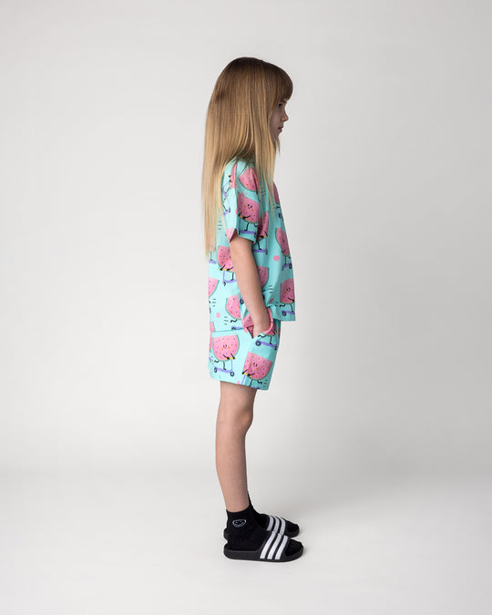 Kid wearing the Scooting Watermelon Tee in light mint with the Scooting Watermelon Short in light mint, side view
