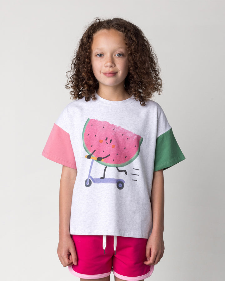 Close up of the Scooting Watermelon Tee in white marle, candy and green on a kid, front view