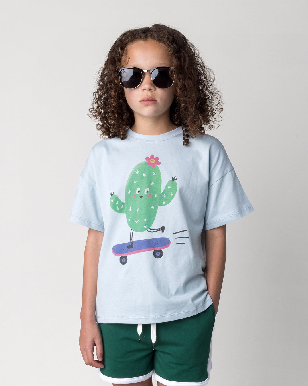 Close up of the Skate Cactus Tee in light blue on a kid, front view
