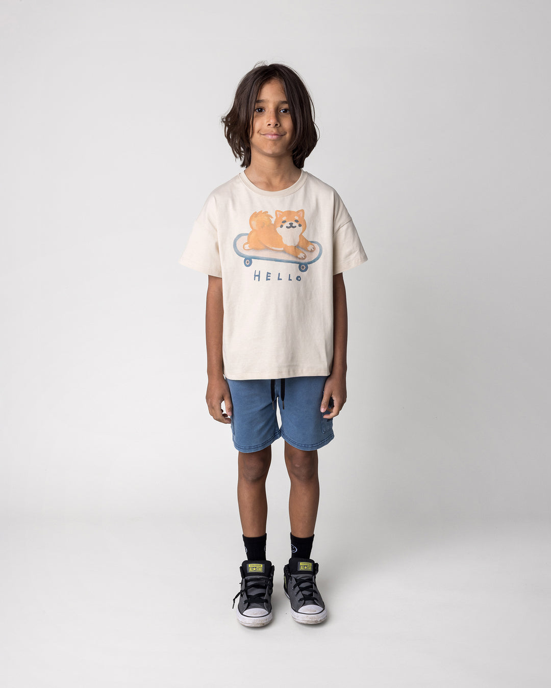 Kid wearing the Skate Puppy Tee in stone with the Blasted Deluxe Cargo Short in midnight wash, front view