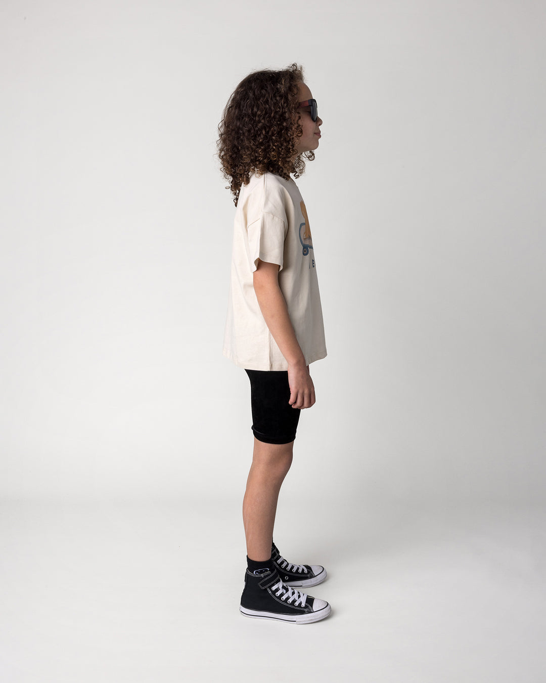 Kid wearing the Skate Puppy Tee in stone with the Velvet Bike Pant in black, side view
