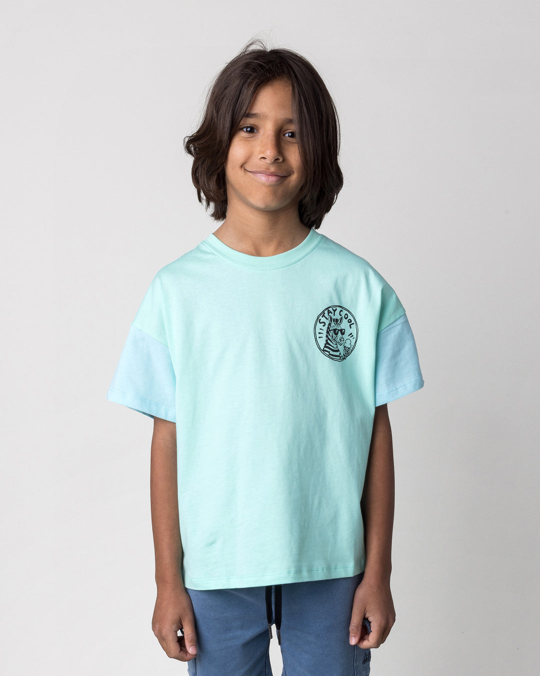 Close up of the Stay Cool Tee in seafoam and light aqua on a kid, front view