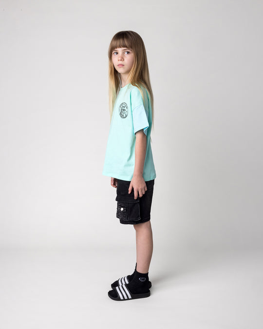 Kid wearing the Stay Cool Tee in seafoam and light aqua, side view