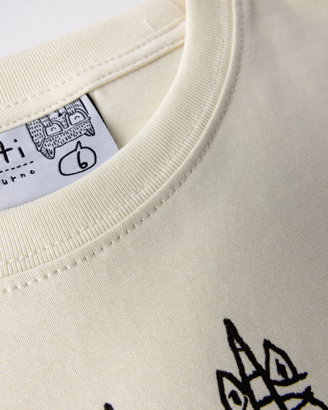 Close up detail of the Unicorn Club Tee in cream