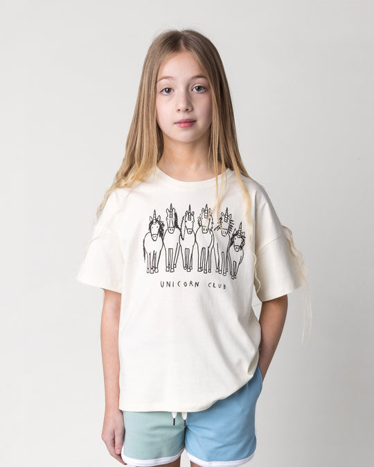 Close up of the Unicorn Club Tee in cream on a kid, front view