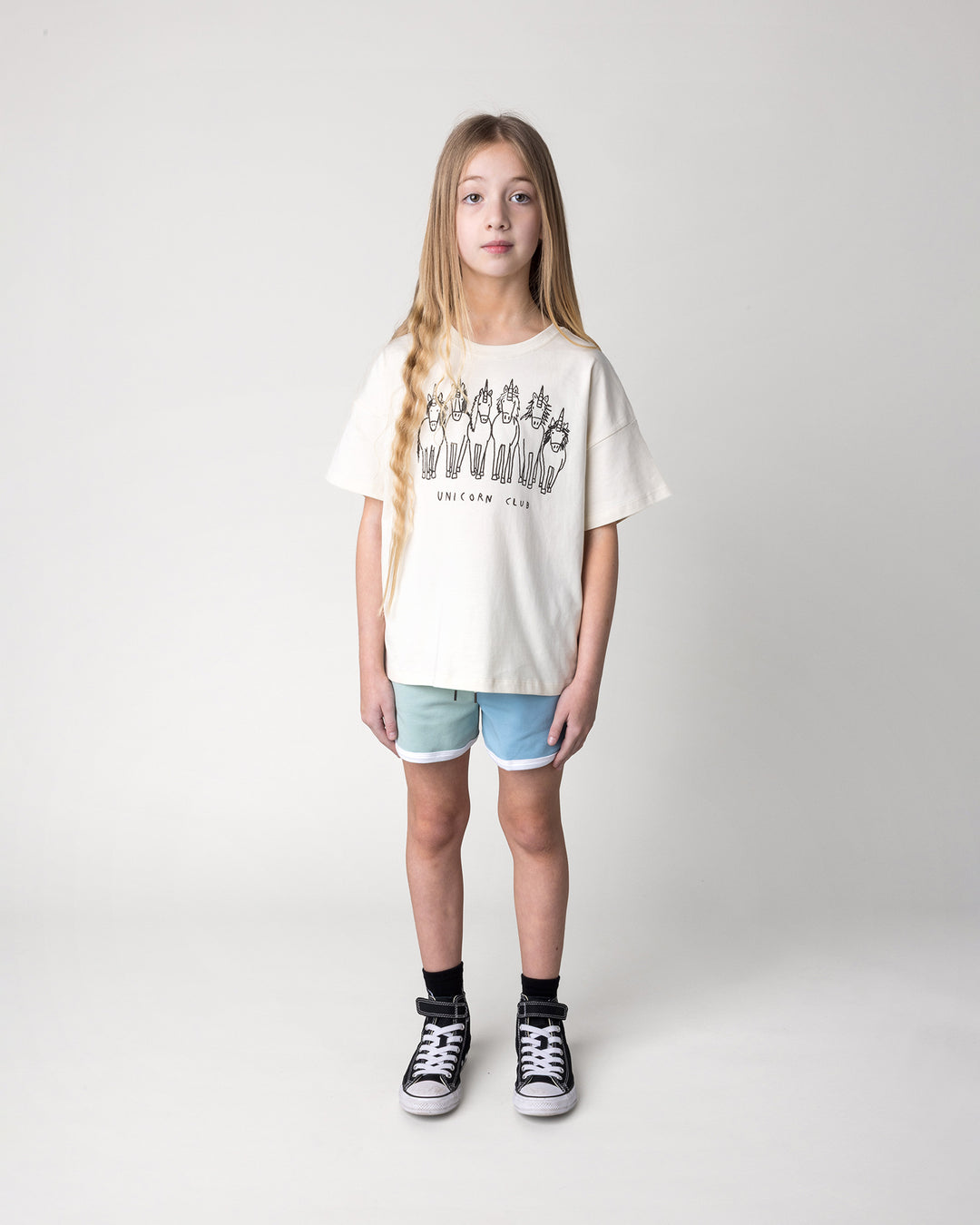Kid wearing the Unicorn Club Tee in cream with the Sprint Short in mint, aqua and lilac, front view