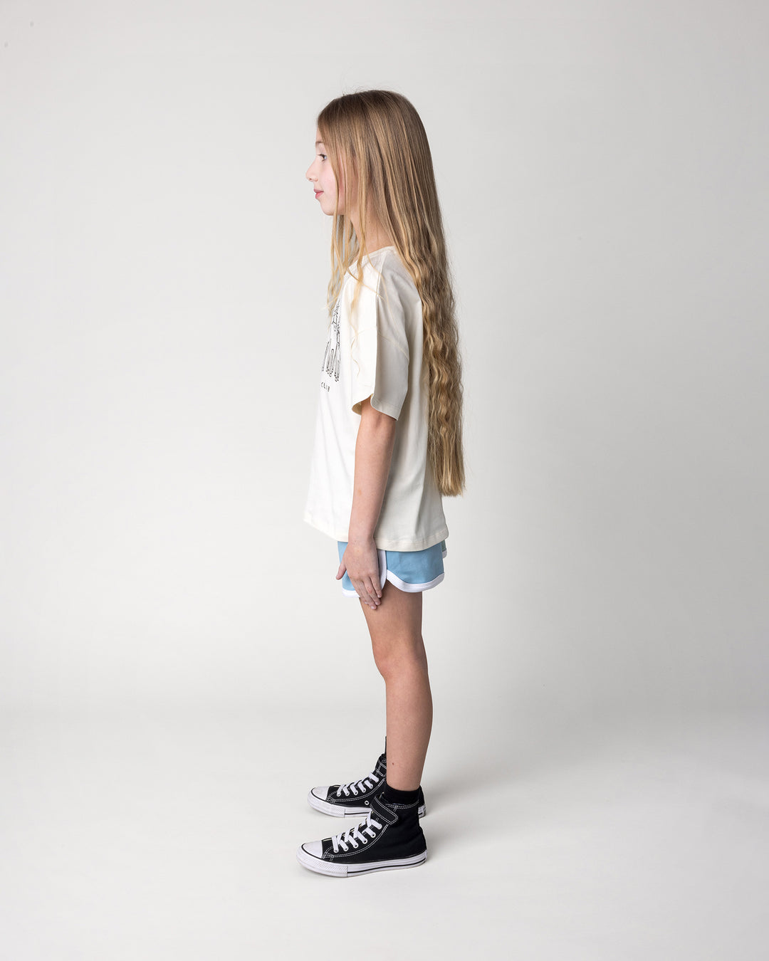 Kid wearing the Unicorn Club Tee in cream with the Sprint Short in mint, aqua and lilac, side view