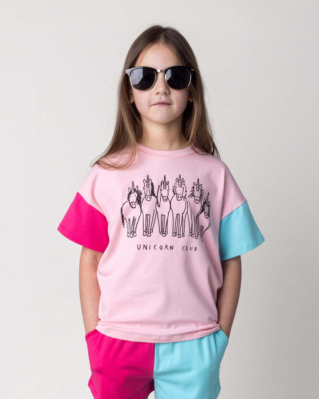Close up of the Unicorn Club Tee in pink, hot pink and aqua on a kid, front view