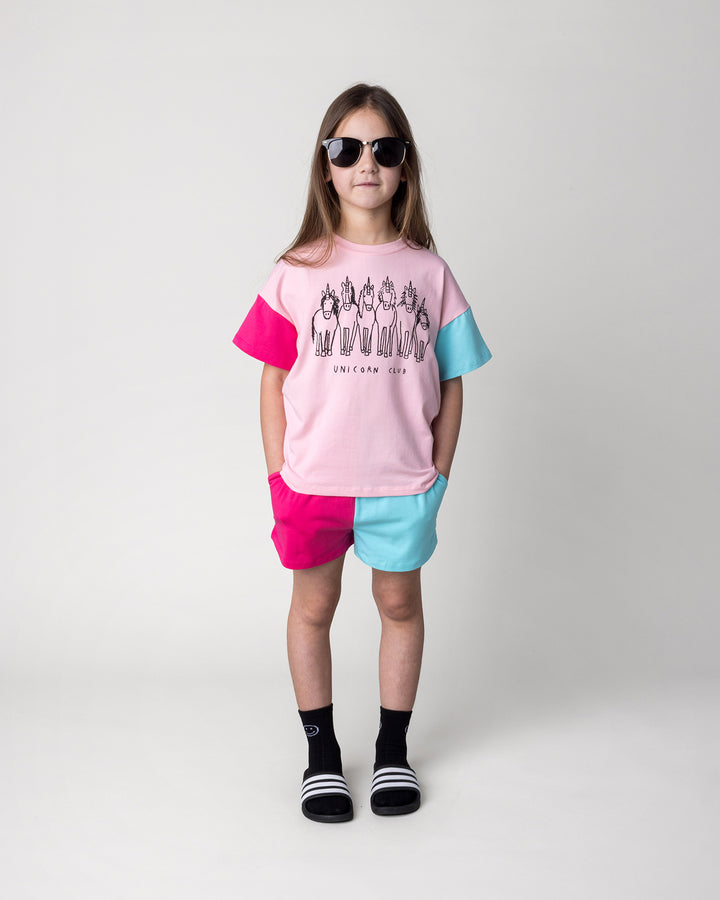 Kid wearing the Unicorn Club Tee in pink, hot pink and aqua with the Two Tone Short in hot pink and aqua, front view