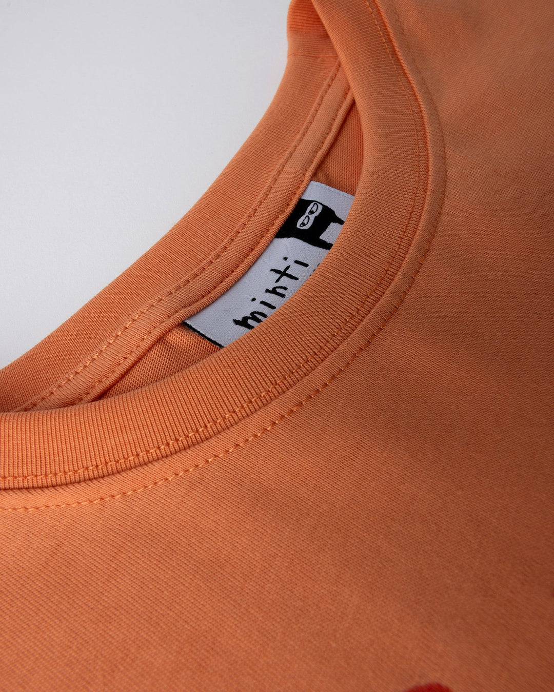 Close up detail of the Vacay Crayfish Tee in light orange