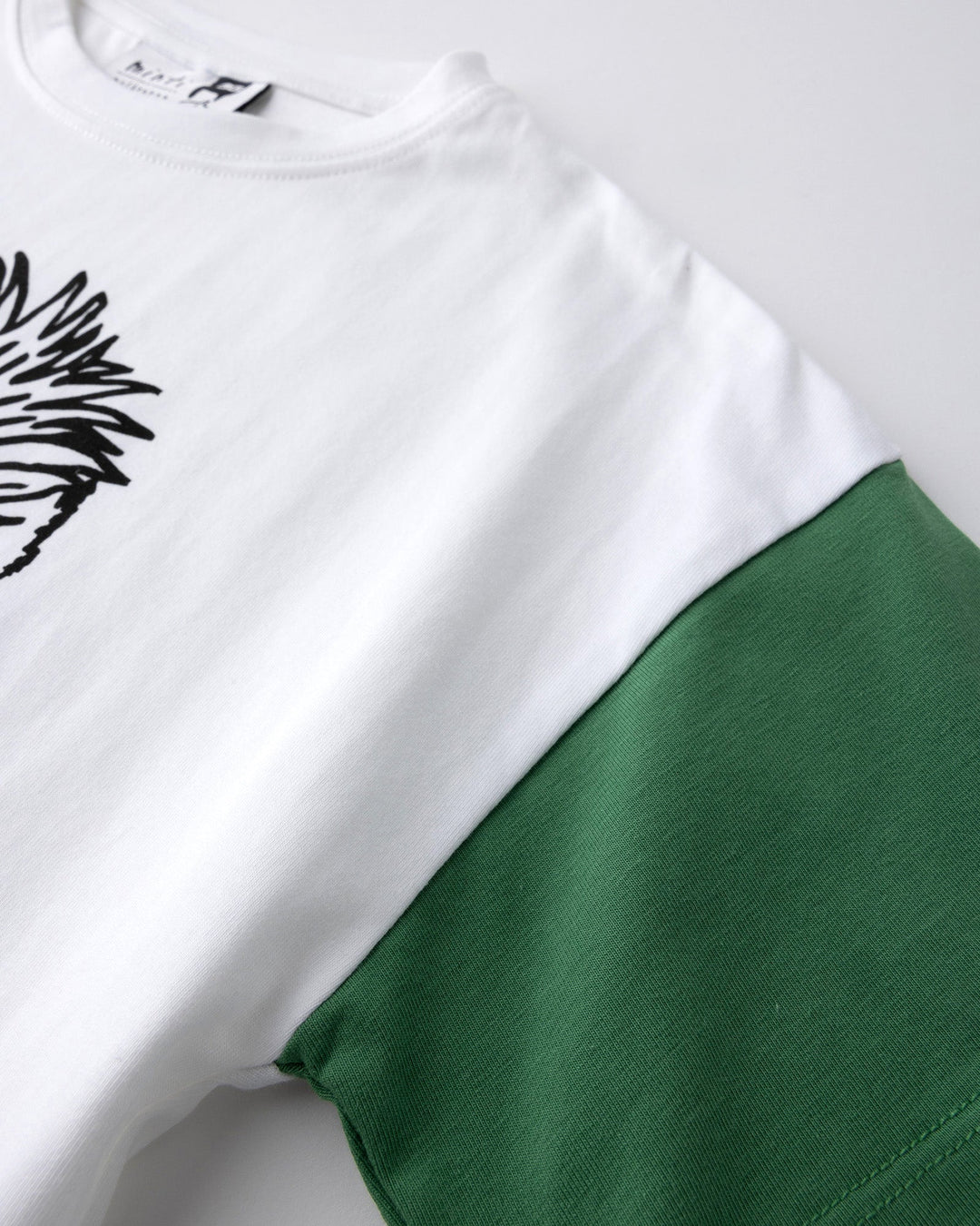 Close up detail of the Werewolf Rockstar Tee in off white, mustard and turf