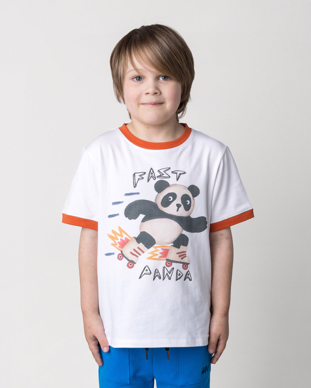 Close up of the Fast Panda Tee in white and orange on a kid, front view