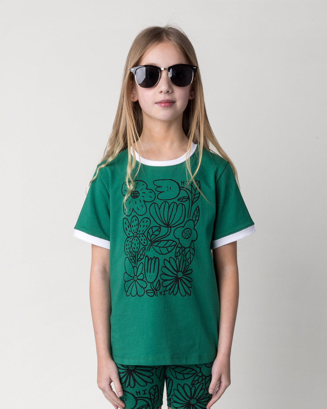 Close up of the Flower Party Tee in kelly green and white on a kid, front view
