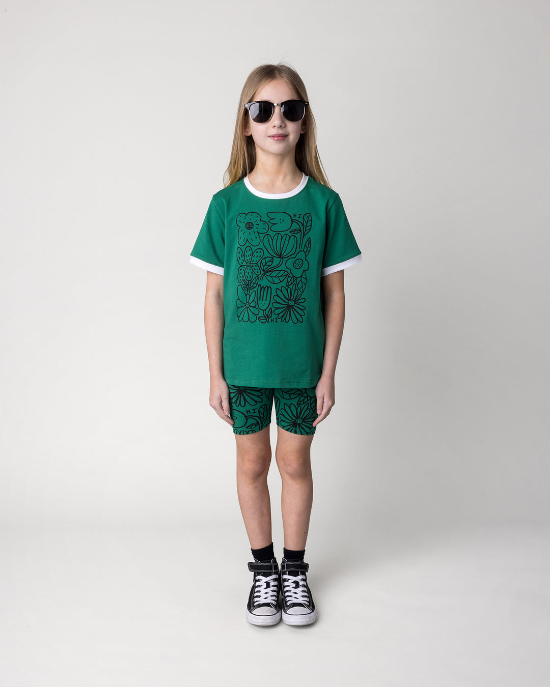 Kid wearing the Flower Party Tee in kelly green and white with the Big Flowers Bike Pant in kelly green, front view