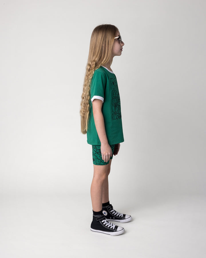 Kid wearing the Flower Party Tee in kelly green and white with the Big Flowers Bike Pant in kelly green, side view