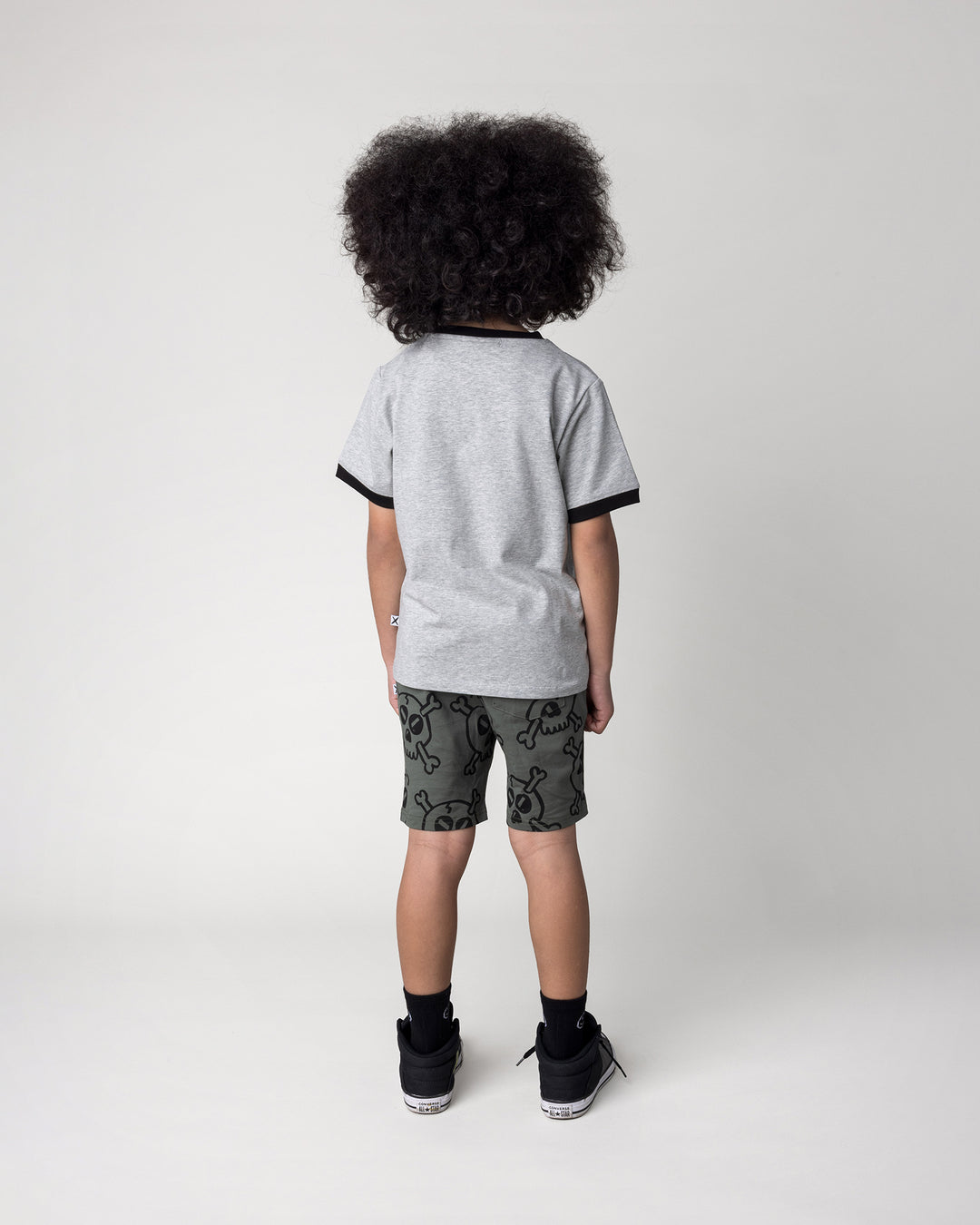 Kid wearing the Hello Skull Tee in grey marle and black with the Hello Skull Short in forest, back view