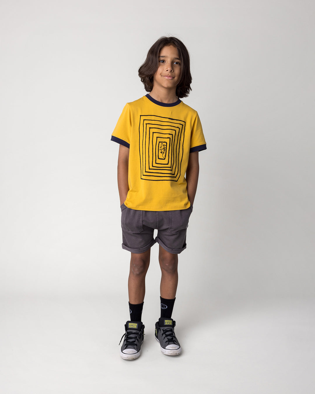 Kid wearing the Hidden Panda Tee in mustard and ink with the Blasted Roller Short in black wash, front view