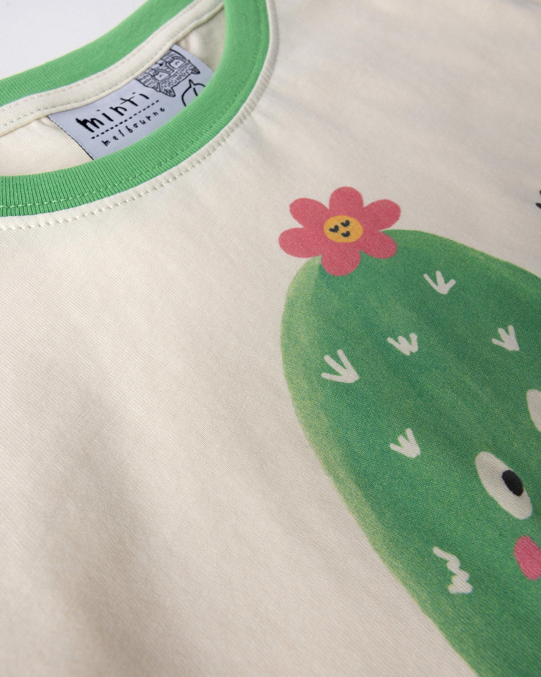 Close up of the Skate Cactus Tee print in cream and green