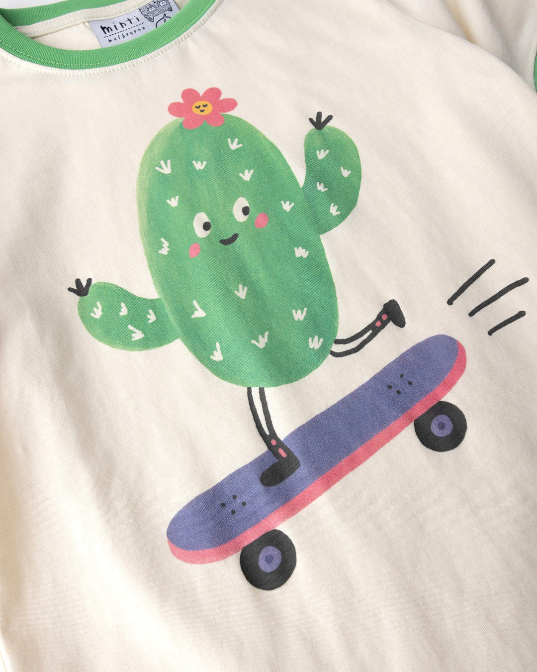 Close up of the Skate Cactus Tee print in cream and green