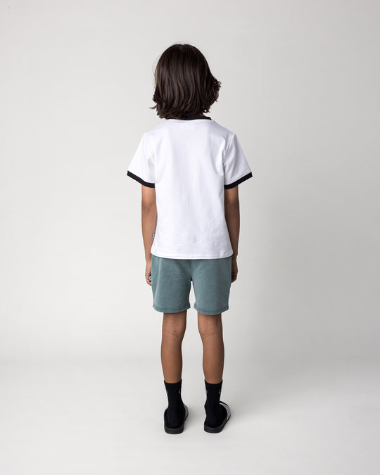 Kid wearing the Skate Ghost Tee in white and black with the Blasted Track Short in forest wash, back view