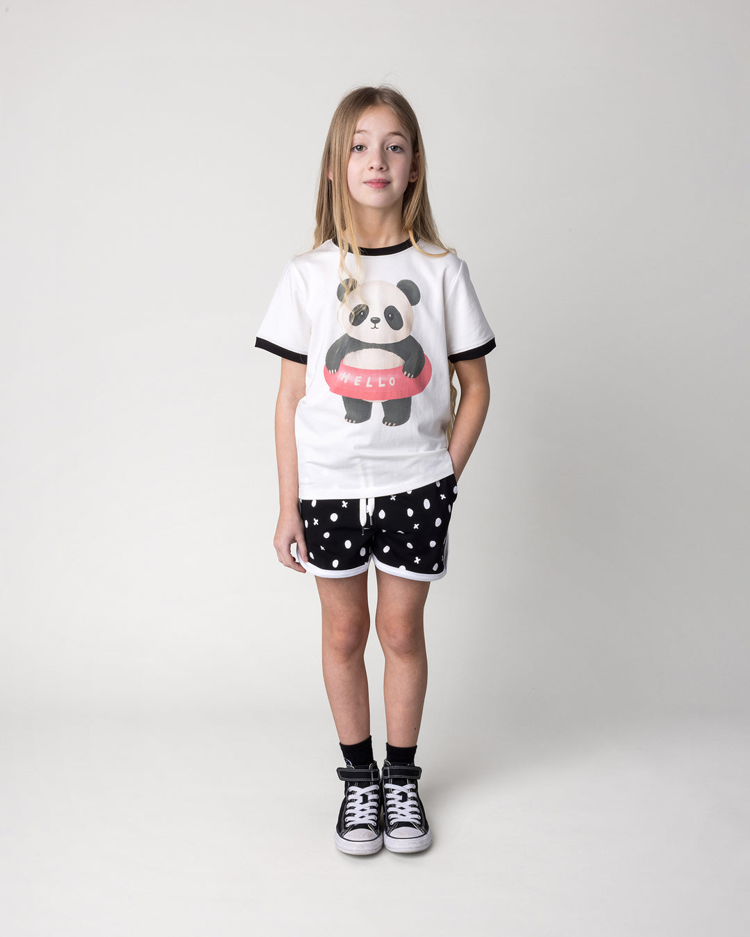 Kid wearing the Swimming Panda Tee in white and black with the Spotty Short in black and white, front view