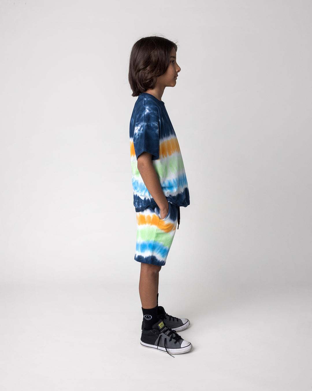 Kid wearing the Airwaves Tee in navy with the Airwaves Short in navy, side view