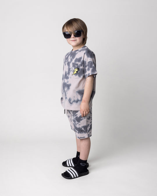Kid wearing the Splatter Tee in grey with the Splatter Short in grey, side view
