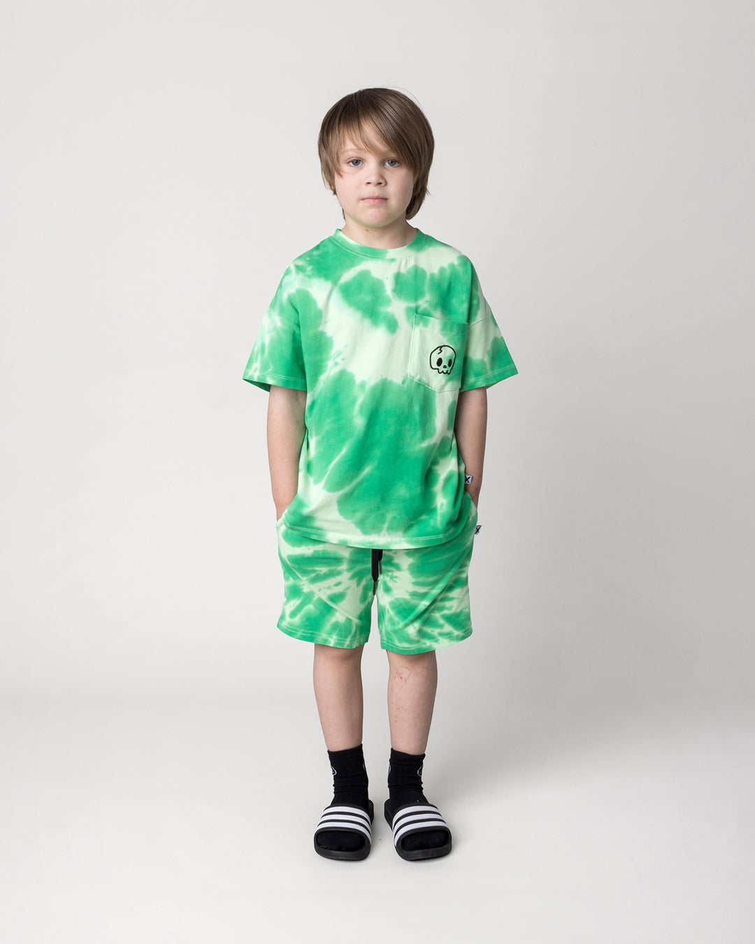 Kid wearing the Splatter Tee in green with the Splatter Short in green, front view