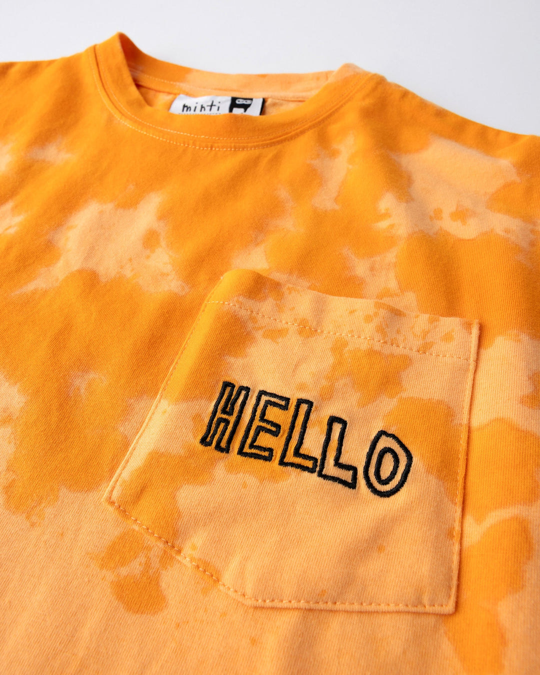 Close up detail of the Splatter Tee in orange