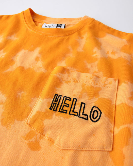 Close up detail of the Splatter Tee in orange