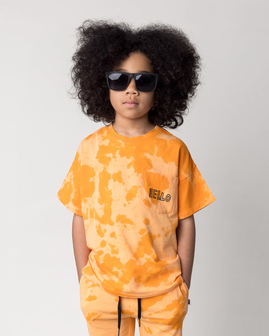Close up of the Splatter Tee in orange on a kid, front view