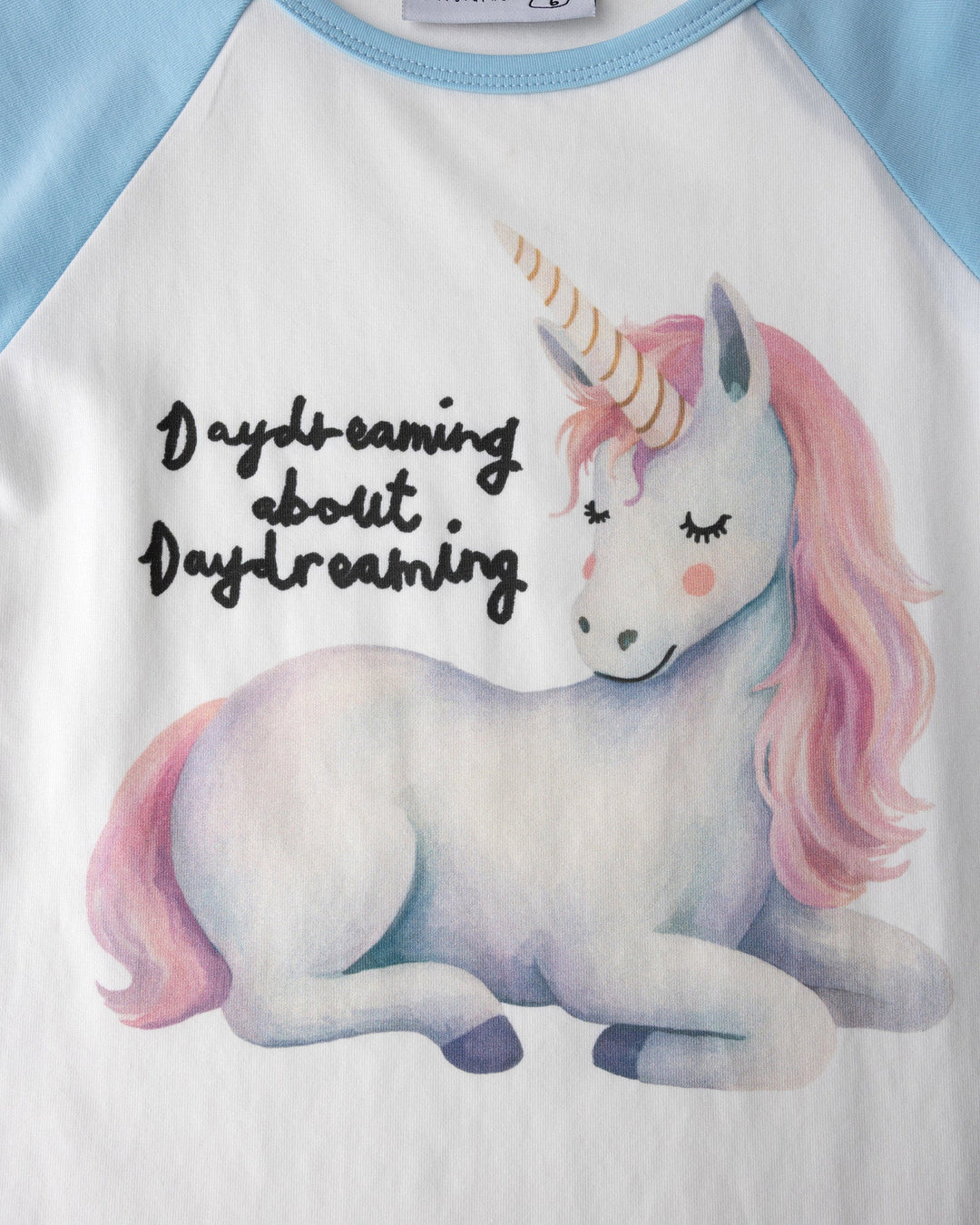 Close up of the Daydreaming Unicorn Tee print in white and light blue