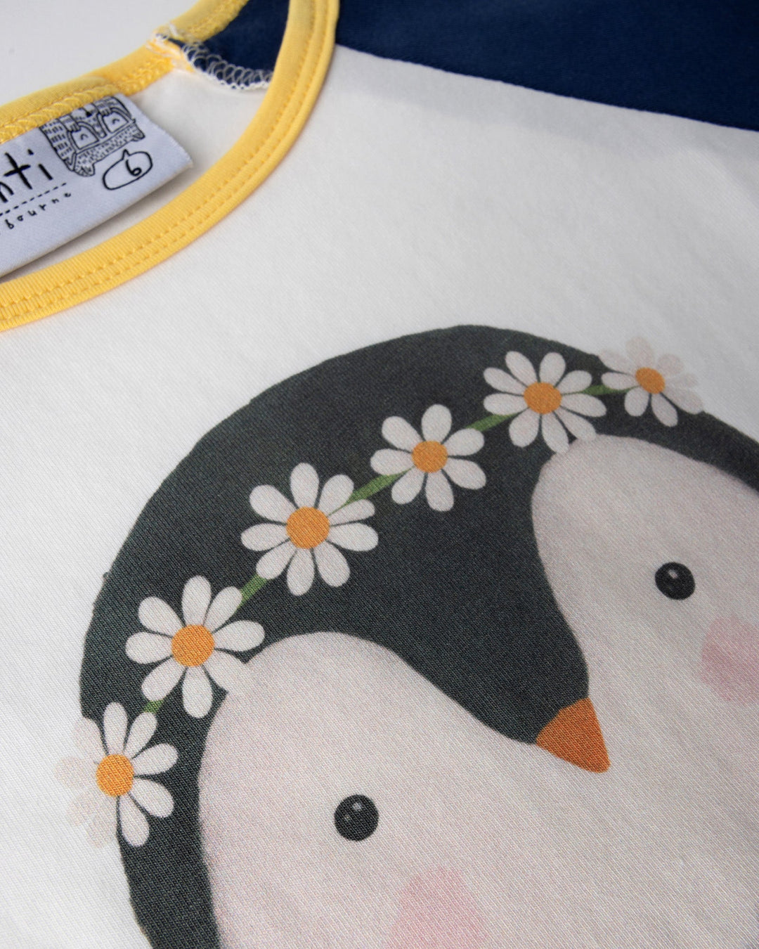 Close up of the Flower Penguin Tee print in white, ink and yellow