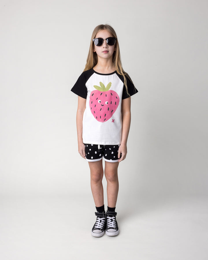 Kid wearing the Happy Strawberry Tee in white and black with the Spotty Short in black and white, front view